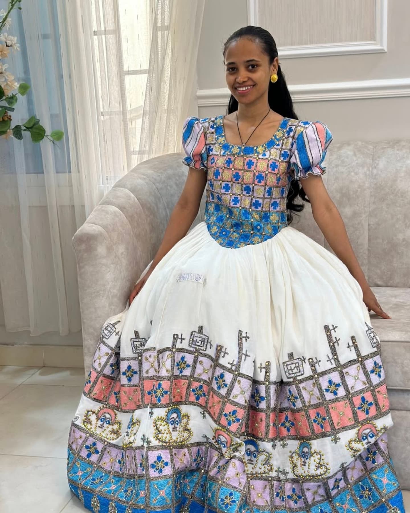 Woman wearing a colorful traditional outfit with a white background