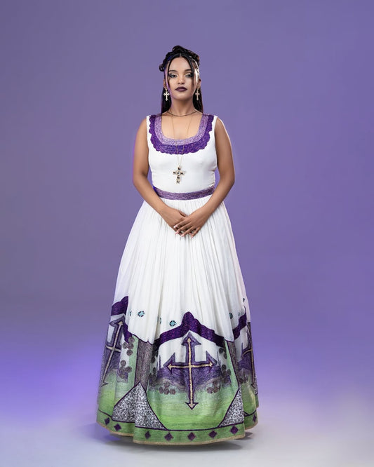 Woman wearing a white dress with purple and green patterns on a purple background
