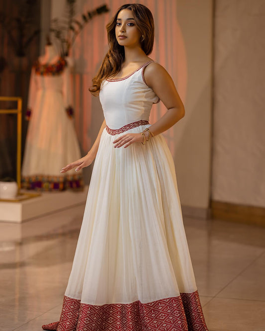 Woman wearing a white and red dress in a store setting