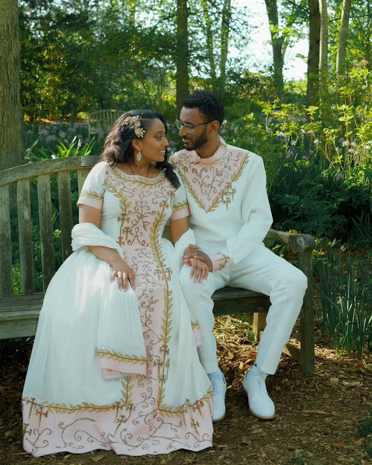 Couple in formal attire sitting on a bench in a garden setting