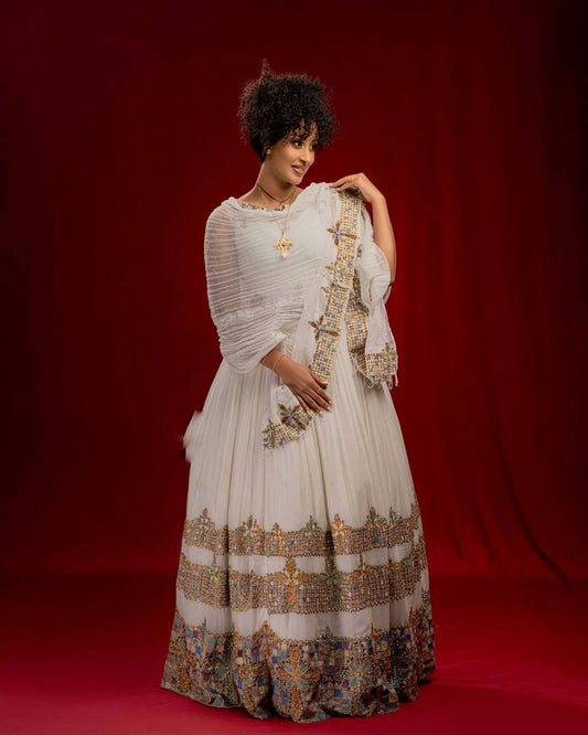 Woman in a white and patterned traditional outfit against a red background